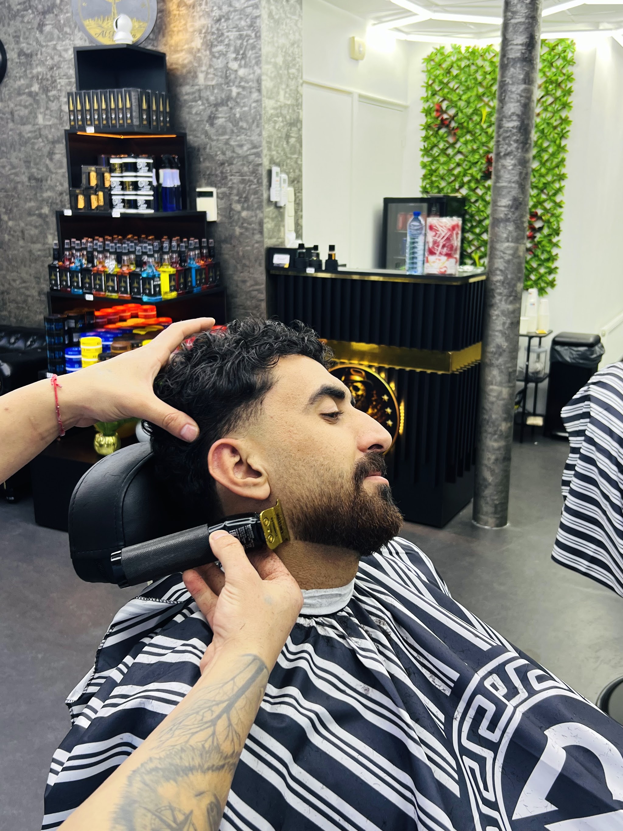 De barbier werkt de baardlijn bij in de stoel