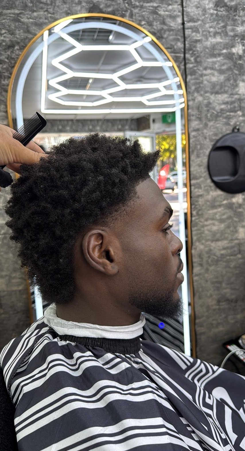 Kort krullend kapsel met een nauwkeurig bijgewerkte zijkant