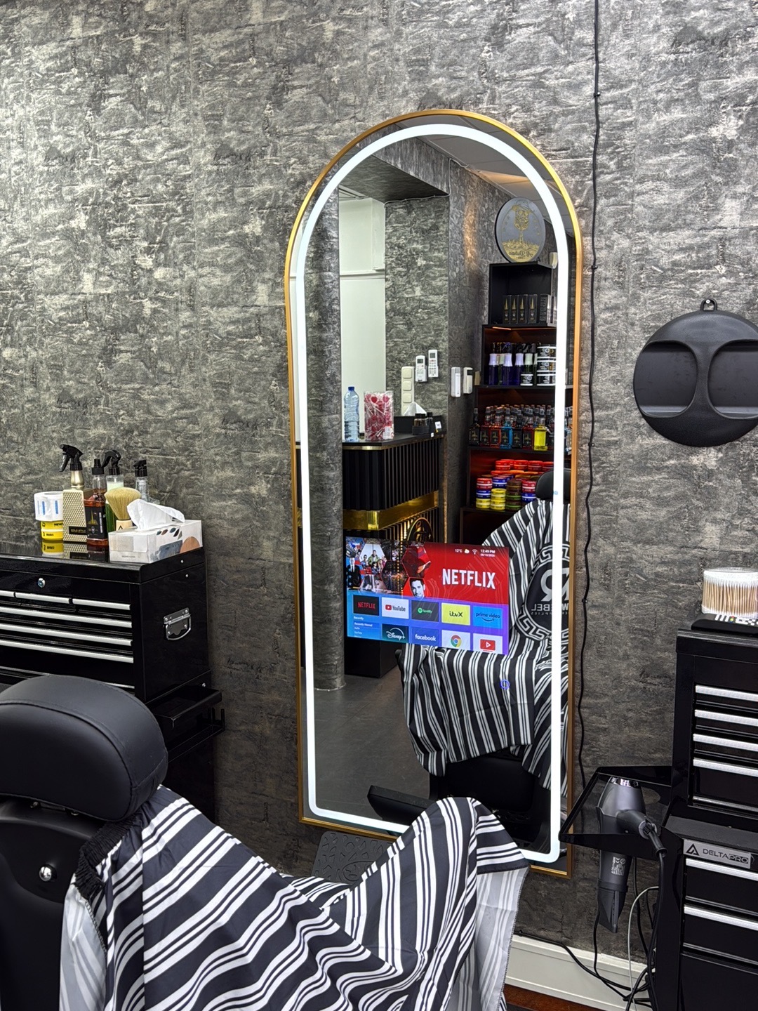 Kappersstoel voor de verlichte boogspiegel in de barbershop